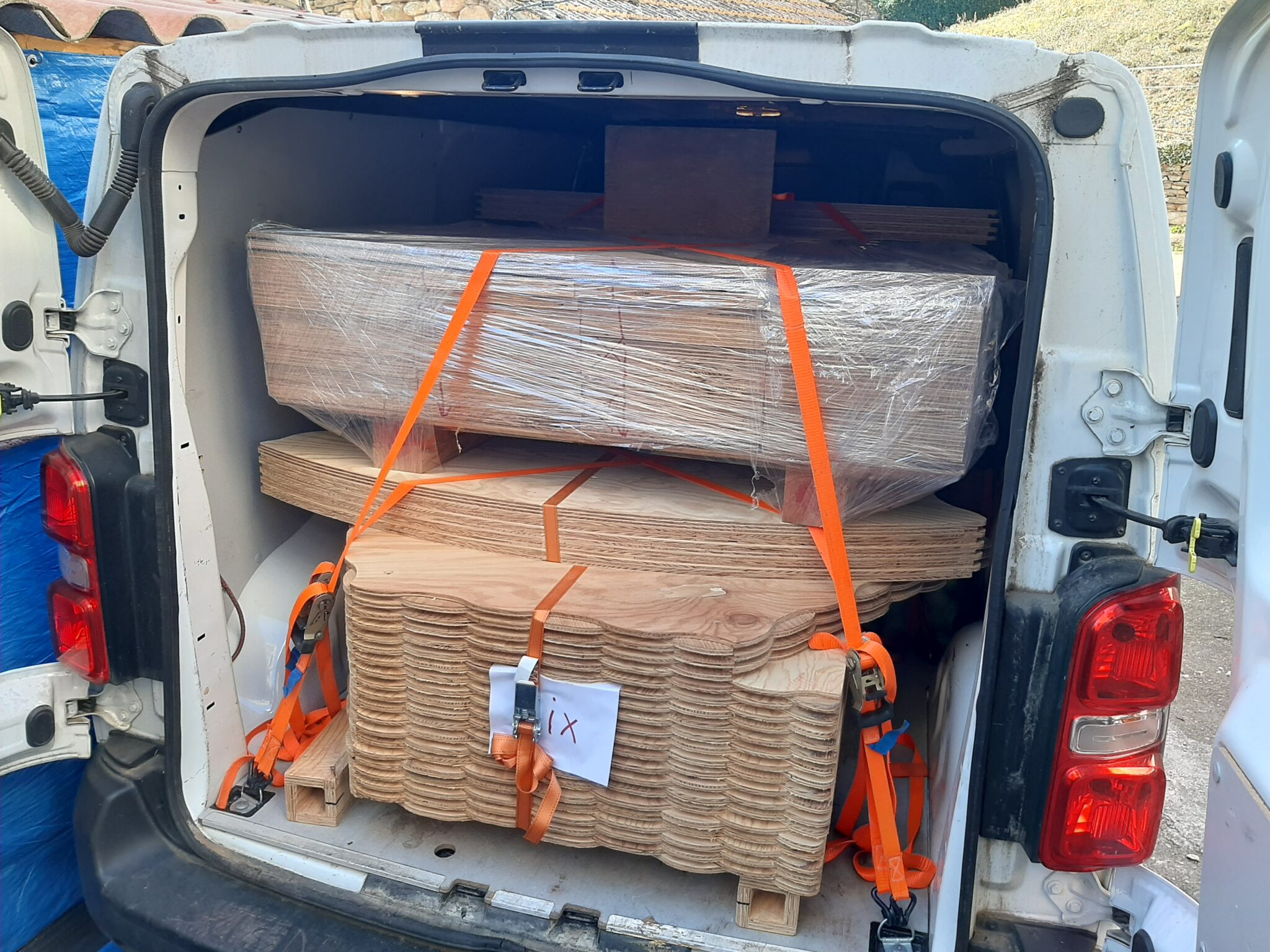 Coffre de camionnette ouvert contenant des piles d'alvéoles